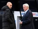 Steve Bruce, manager of Newcastle United, interacts with Pep Guardiola, Manager of Manchester City.