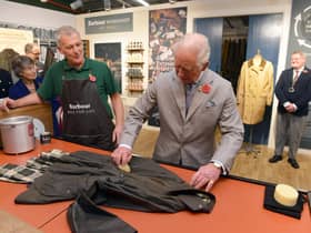 The Prince of Wales turns his hand to re-waxing a Barbour jacket.