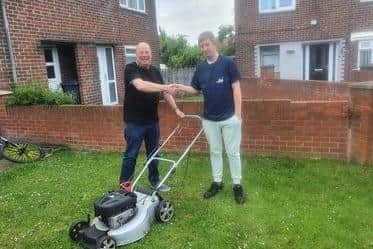 Brian Smith, left and Devlin Pape with the new mower.