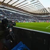 A TV camera films the action during a Premier League match at St James's Park.