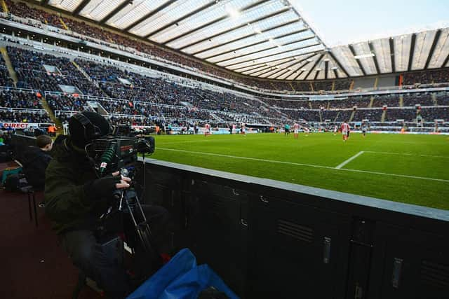 A TV camera films the action during a Premier League match at St James's Park.