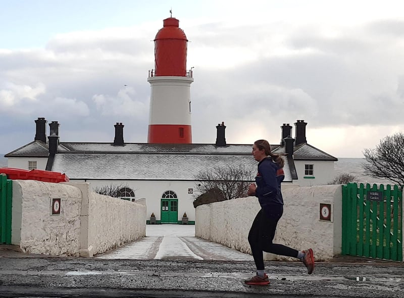 A jogger braves the cold as snow falls on Souter Lighthouse last year.