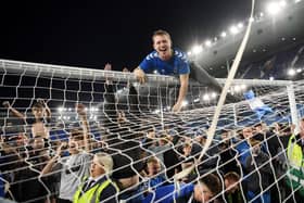 Everton fans celebrate on the pitch at Goodison Park.