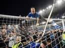 Everton fans celebrate on the pitch at Goodison Park.