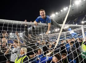 Everton fans celebrate on the pitch at Goodison Park.