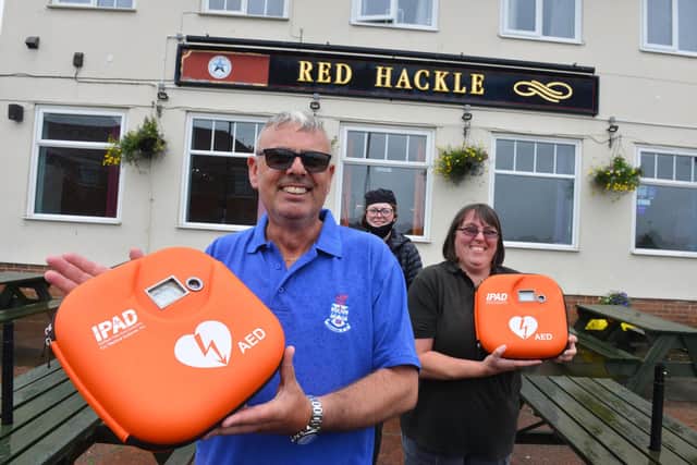 The Red Hackle pub owner Lee Hughes with Dickson Butchers Laura Nixon and McColl's Gillian Jeffries with the two AEDs public access defibrillators.
