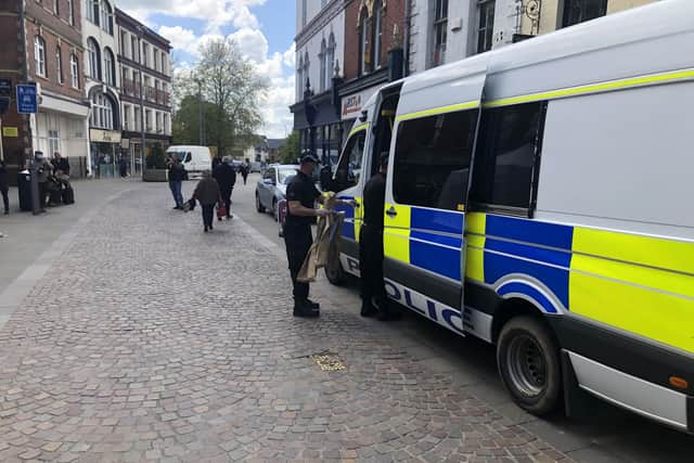 Police officers carry evidence bags from the The Clean Plate cafe in Southgate Street, Gloucester. Picture date: Tuesday May 11, 2021.