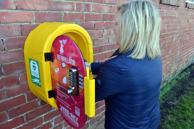 West Park Community Group chairperson Alison Docherty at the new defibrillator. Picture by Stu Norton.