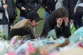 Women view floral tributes left at the band stand in Clapham Common, London, after clashes between police and crowds who gathered on Clapham Common on Saturday night to remember Sarah Everard. Serving police constable Wayne Couzens, 48, appeared in court on Saturday charged with kidnapping and murdering the 33-year-old marketing executive, who went missing while walking home from a friend's flat in south London on March 3. Picture date: Sunday March 14, 2021.