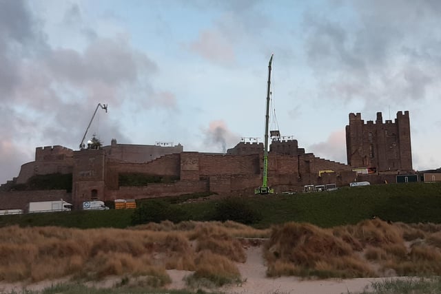 A plume of smoke emerges from the grounds of Bamburgh Castle.