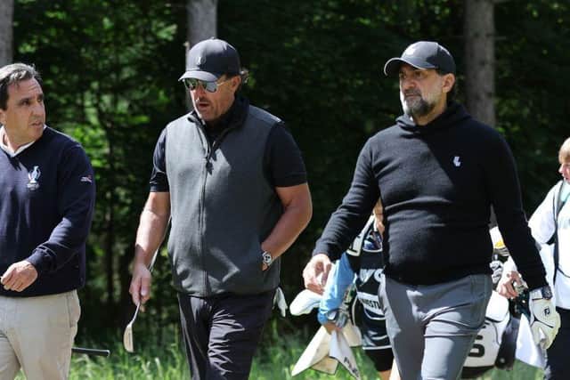 Golfer Phil Mickelson, centre, and Newcastle United chairman Yasir Al-Rumayyan, right, walk as they take part in the Pro-Am round of the LIV Golf Invitational Series event at The Centurion Club in St Albans.