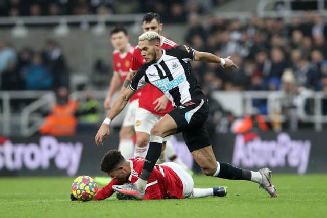 Joelinton of Newcastle United runs with the ball past Jadon Sancho of Manchester United during the Premier League match between Newcastle United  and  Manchester United at St James' Park on December 27, 2021 in Newcastle upon Tyne, England. (Photo by Ian MacNicol/Getty Images)