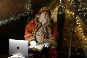 Father Christmas learns how to use Zoom on a laptop in the grotto at Bamburgh castle in Northumberland,