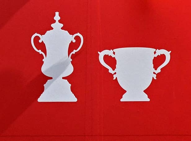 League Cup trophy (R) and FA Cup trophy (L).(Photo by Oli SCARFF / AFP) (Photo by OLI SCARFF/AFP via Getty Images)