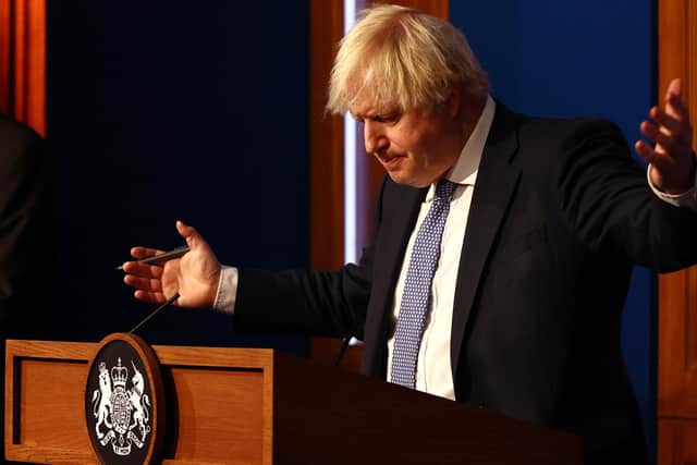 Prime Minister Boris Johnson gestures whilst speaking at a press conference in London's Downing Street after ministers met to consider imposing new restrictions in response to rising cases and the spread of the Omicron variant. Picture date: Wednesday December 8, 2021.
