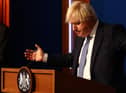 Prime Minister Boris Johnson gestures whilst speaking at a press conference in London's Downing Street after ministers met to consider imposing new restrictions in response to rising cases and the spread of the Omicron variant. Picture date: Wednesday December 8, 2021.