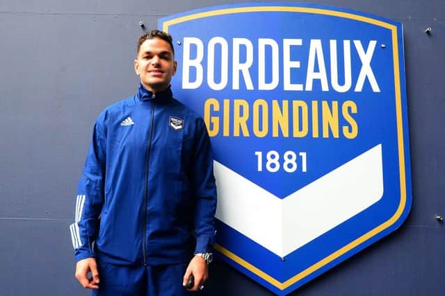 New Bordeaux French forward Hatem Ben Arfa poses past the logo of his new team during a press conference held for his presentation at the Matmut Stadium in Bordeaux on October 8, 2020. (Photo by MEHDI FEDOUACH / AFP) (Photo by MEHDI FEDOUACH/AFP via Getty Images)