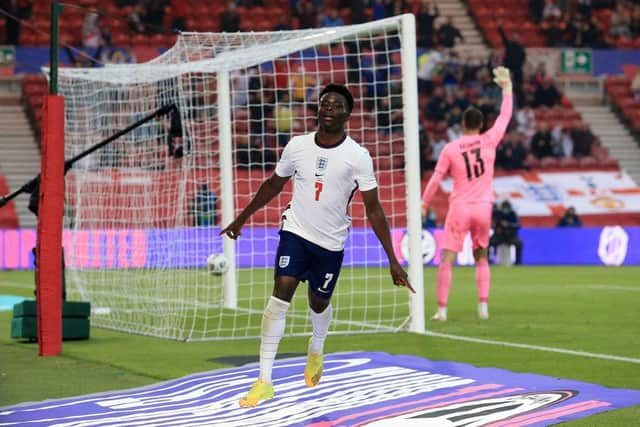 England's defender Bukayo Saka celebrates scoring the opening goal during the international friendly football match between England and Austria at the Riverside Stadium.