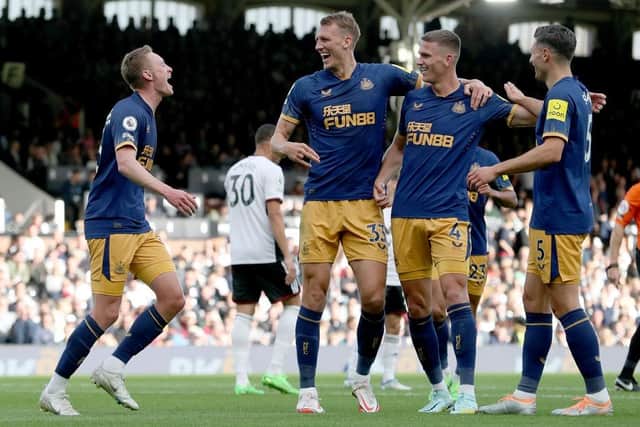 Sean Longstaff of Newcastle United celebrate with team mates Dan Burn, Sven Botman and Fabian Schar after scoring their sides third goal during the Premier League match between Fulham FC and Newcastle United at Craven Cottage on October 01, 2022 in London, England. (Photo by Henry Browne/Getty Images)