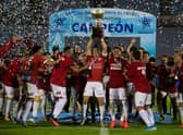 Rentistas' captain, Andres Rodales (C), holds up the trophy after winning Uruguay's Apertura tournament final football match against Nacional in Montevideo.