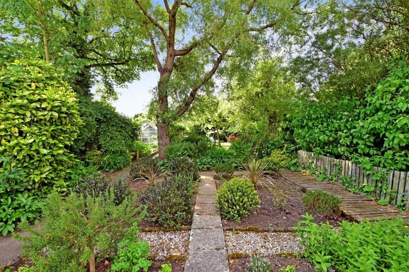 The grounds include a vegetable garden with greenhouse and an orchard