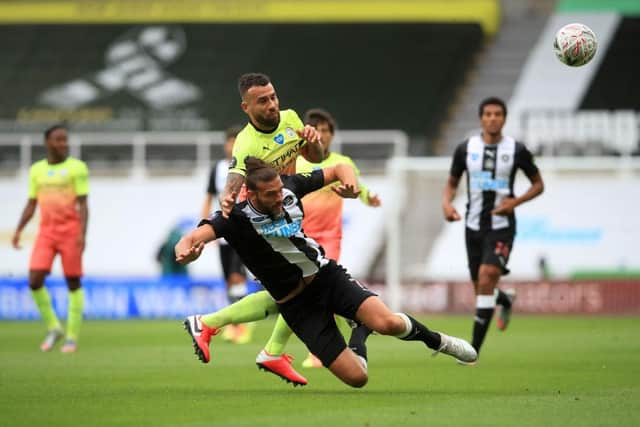 NEWCASTLE UPON TYNE, ENGLAND - JUNE 28: Nicolas Otamendi of Manchester City battles for possession with Andy Carroll of Newcastle United  during the FA Cup Quarter Final match between Newcastle United and Manchester City at St. James Park on June 28, 2020 in Newcastle upon Tyne, England. (Photo by Owen Humphreys/Pool via Getty Images)