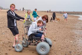 Thomas Lawton, Maureen Morris and Kelly Lawton accompany Hannah Lawton as she puts one of the beach accessible wheelchairs to the test at Roker.