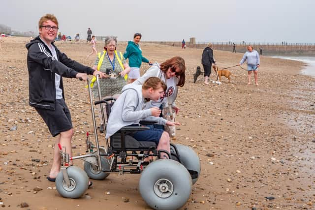 Thomas Lawton, Maureen Morris and Kelly Lawton accompany Hannah Lawton as she puts one of the beach accessible wheelchairs to the test at Roker.