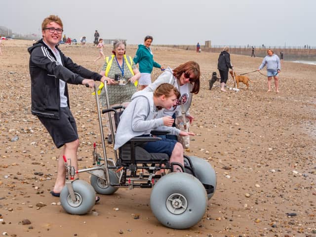 Thomas Lawton, Maureen Morris and Kelly Lawton accompany Hannah Lawton as she puts one of the beach accessible wheelchairs to the test at Roker.