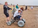 Thomas Lawton, Maureen Morris and Kelly Lawton accompany Hannah Lawton as she puts one of the beach accessible wheelchairs to the test at Roker.
