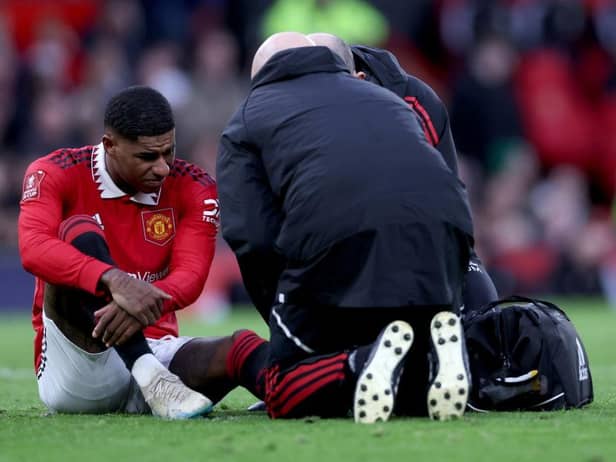 Marcus Rashford of Manchester United receives medical treatment during the Emirates FA Cup Quarter Final match between Manchester United and Fulham at Old Trafford on March 19, 2023 in Manchester, England. (Photo by Clive Brunskill/Getty Images)