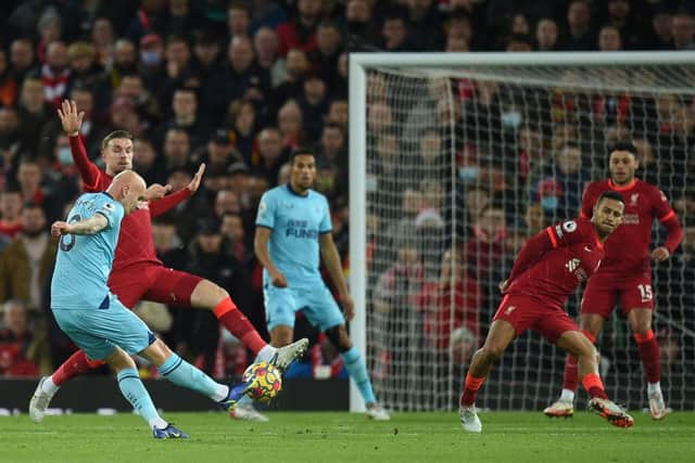 Newcastle United's English midfielder Jonjo Shelvey (L) shoots to score the opening goal of the English Premier League football match between Liverpool and Newcastle United at Anfield in Liverpool, north west England on December 16, 2021. (Photo by OLI SCARFF/AFP via Getty Images)