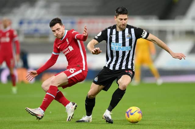 Federico Fernandez of Newcastle United turns away from Andrew Robertson of Liverpool during the Premier League match between Newcastle United and Liverpool at St. James' Park on December 30, 2020 in Newcastle upon Tyne, England.
