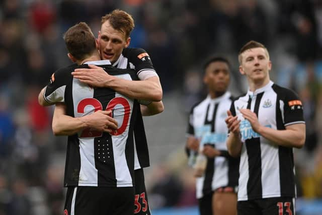 Dan Burn embraces Chris Wood of Newcastle United after their sides victory during the Premier League match between Newcastle United and Brighton & Hove Albion at St. James Park on March 05, 2022 in Newcastle upon Tyne, England. (Photo by Stu Forster/Getty Images)