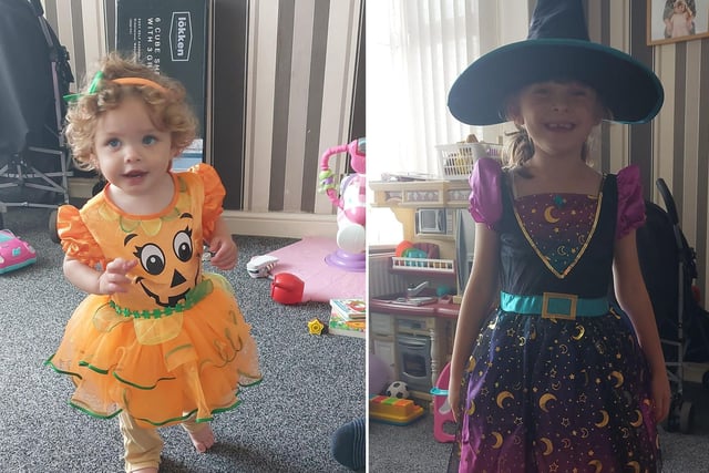 Ava, 18 months, in her pumpkin outfit and Amelia, age 7, in a fantastic witch's costume and matching hat.