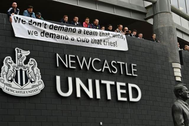 Newcastle United fans stand behind a banner as they arrive at St James' Park in Newcastle-upon-Tyne, north east England on October 17, 2021 for the English Premier League football match between Newcastle United and Tottenham Hotspur, Newcastle's first match since the club was taken over by a wealthy Saudi-led consortium.  (Photo by PAUL ELLIS/AFP via Getty Images)