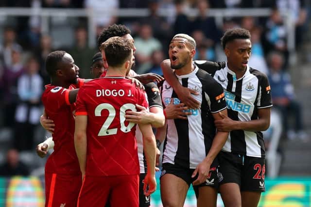 Newcastle United's Joelinton clashes with Liverpool's Diogo Jota.