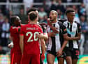 Newcastle United's Joelinton clashes with Liverpool's Diogo Jota.