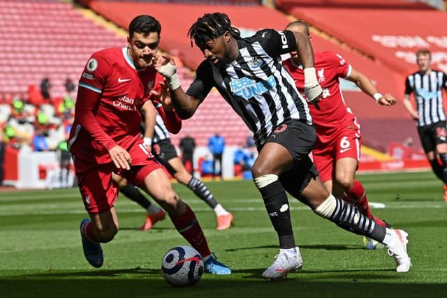 Ozan Kabak vies with Allan Saint-Maximin at Anfield.