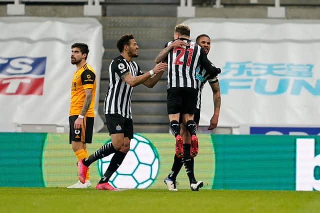Jamaal Lascelles of Newcastle United celebrates with team mates Ryan Fraser and Joelinton after scoring their side's first goal during the Premier League match between Newcastle United and Wolverhampton Wanderers at St. James Park on February 27, 2021 in Newcastle upon Tyne, England.