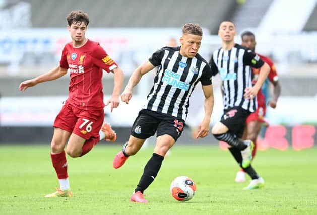 Dwight Gayle of Newcastle United gets away from Neco Williams of Liverpool during the Premier League match between Newcastle United and Liverpool FC at St. James Park on July 26, 2020 in Newcastle upon Tyne, England.