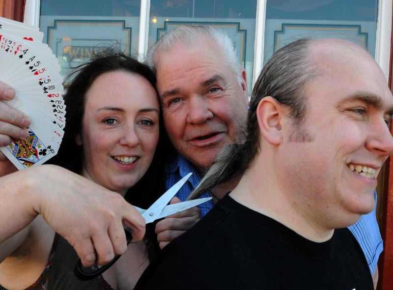 Kathleen Brain prepares to cut the ponytail of Steamboat regular Peter Swalwell, with magician George Dunn watching in this 2011 photo.