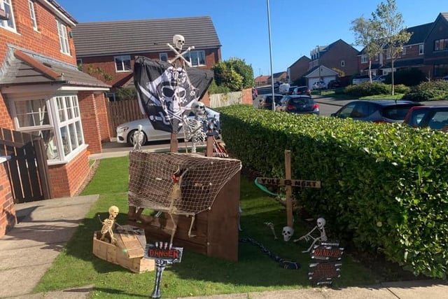 Skeletons aboard a pirate ship outside this house. Enter if you dare!
