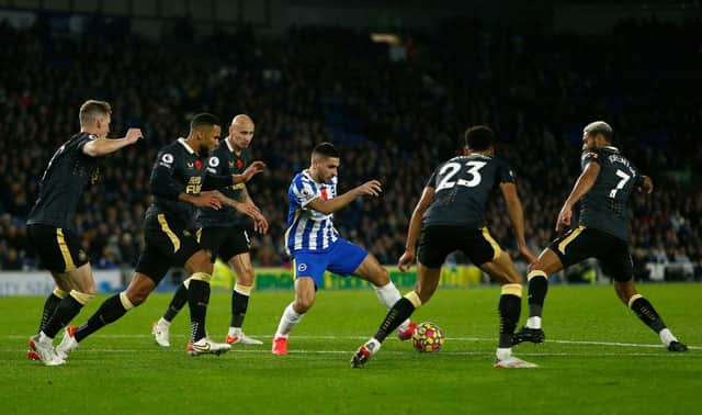 Neal Maupay of Brighton & Hove Albion runs with the ball from Jacob Murphy and Joelinton of Newcastle United during the Premier League match between Brighton & Hove Albion and Newcastle United. (Photo by Charlie Crowhurst/Getty Images)