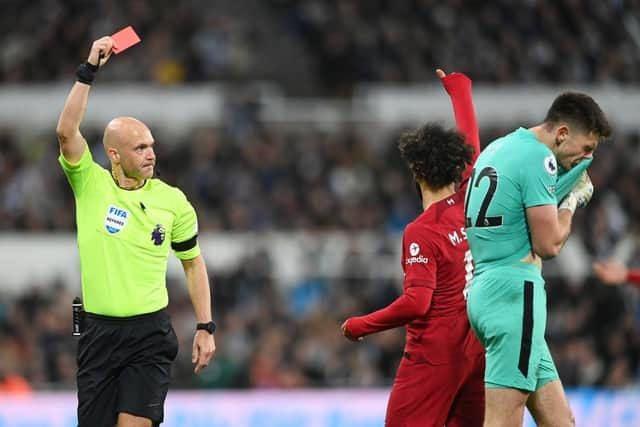 Referee Anthony Taylor shows a red card to Nick Pope of Newcastle United during the Premier League match between Newcastle United and Liverpool FC at St. James Park on February 18, 2023 in Newcastle upon Tyne, England. (Photo by Stu Forster/Getty Images)