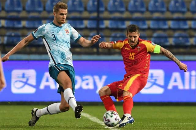 Norway's Kristoffer Ajer (L) fights for the ball with Montenegro's Stevan Jovetic (R) during the FIFA World Cup Qatar 2022 qualification Group G football match between Montenegro and Norway at the Podgorica City Stadium, in Podgorica, on March 30, 2021.