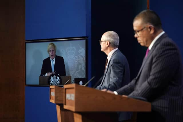 Prime Minister Boris Johnson appears on a screen from Chequers, where he is self-isolating, while chief scientific adviser Sir Patrick Vallance and deputy chief medical officer for England Professor Jonathan Van Tam speak from Downing Street, during a coronavirus briefing. Picture  by PA.