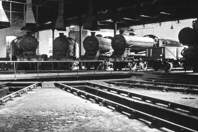 The interior of the roundhouse at Tweedmouth in 1961 was home to four class J39 0-6-0 locos, all too grimy to identify. In 1961, Tweedmouth and Alnmouth were allocated nos 64869, 64897 and 64917.  All the J39 class had been withdrawn by the end of 1962. The wagon with the stripes is a shock absorber wagon for fragile loads. (Colour-Rail.com)