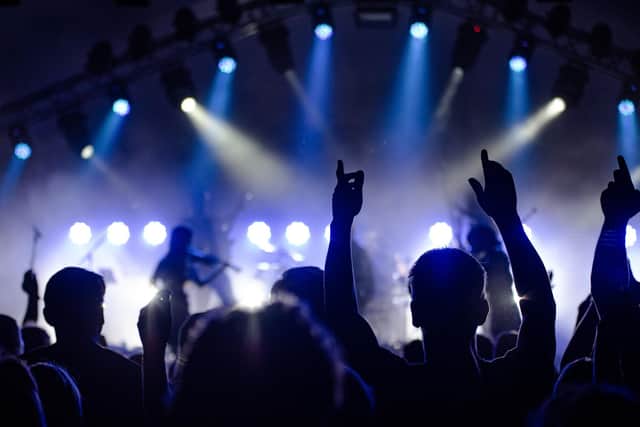 People listening to music and excited at a live music event.