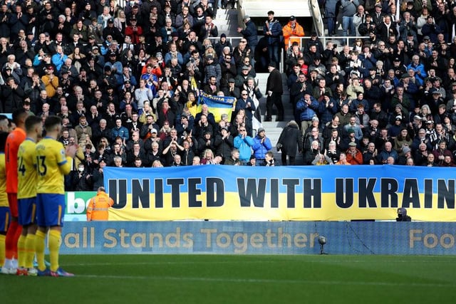 Newcastle United fans in the East Stand hold banners with the Ukrainian flag to indicate peace and sympathy with Ukraine prior to the Brighton and Hove Albion match at St James's Park.